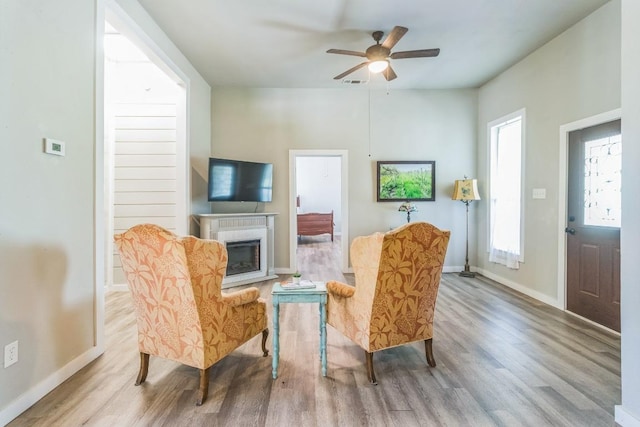 1132 W Clark St, Bartlett, TX 76511 - living area featuring wood finished floors, a glass covered fireplace, baseboards, and ceiling fan