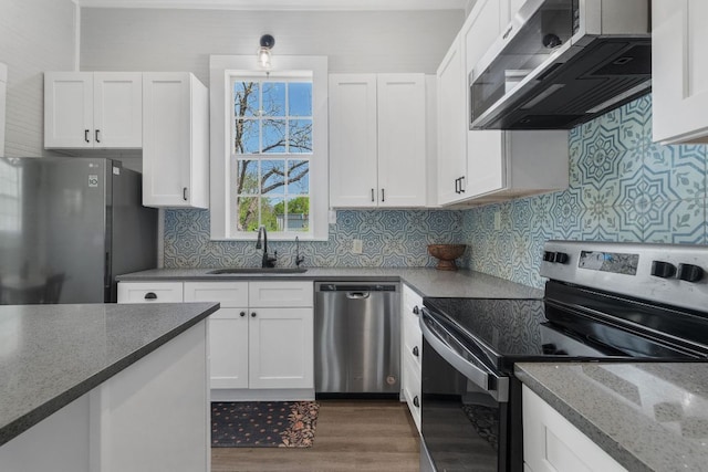 1132 W Clark St, Bartlett, TX 76511 - kitchen featuring stainless steel appliances, a sink, wood finished floors, white cabinets, and backsplash