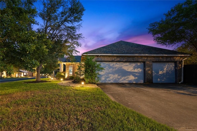 view of front of property with concrete driveway, a garage, a front lawn, brick siding, and a shingled roof