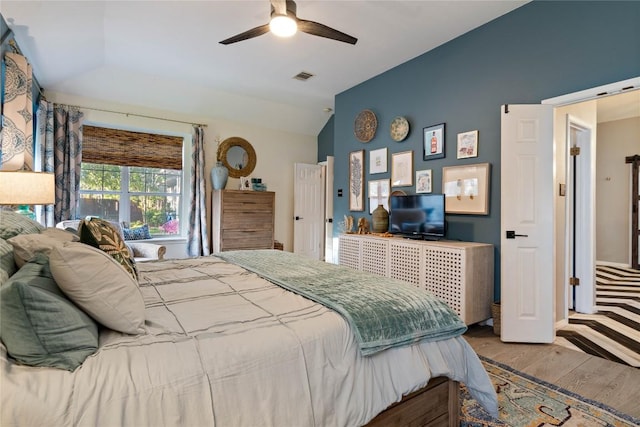 bedroom featuring vaulted ceiling, wood finished floors, and a ceiling fan