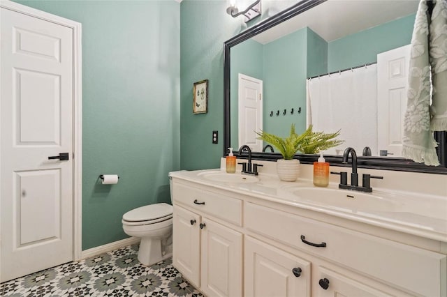 full bathroom featuring toilet, baseboards, and double vanity