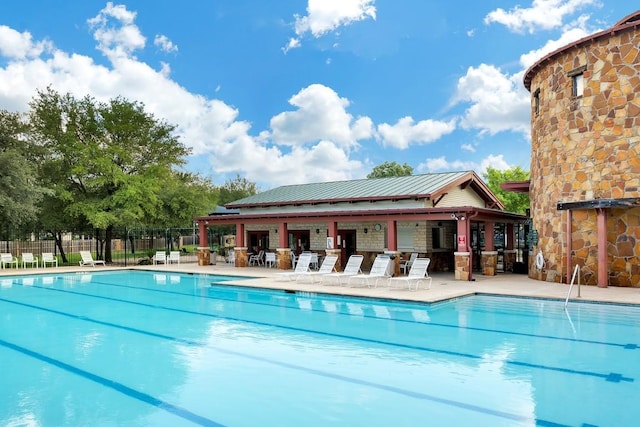 community pool with fence and a patio area