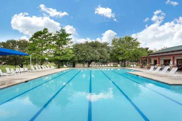 community pool featuring fence and a patio area