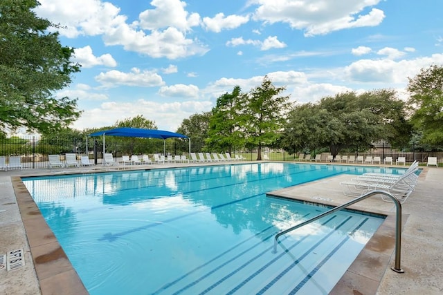 community pool featuring fence and a patio area