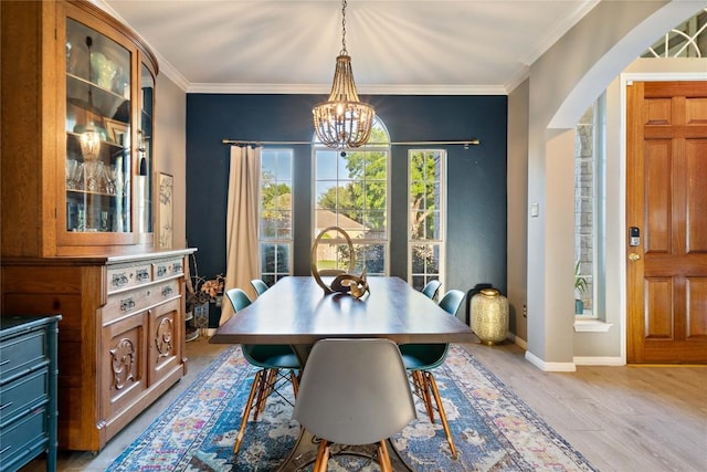 dining area featuring a chandelier, crown molding, light wood-type flooring, and baseboards