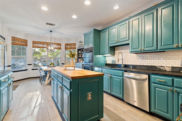 kitchen featuring dishwasher, a sink, butcher block counters, a center island, and backsplash
