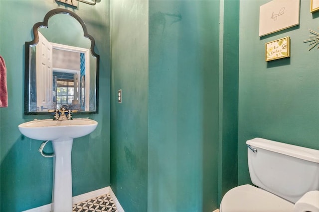 bathroom featuring toilet and baseboards