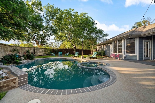 view of swimming pool with a fenced backyard, a patio, and a pool with connected hot tub
