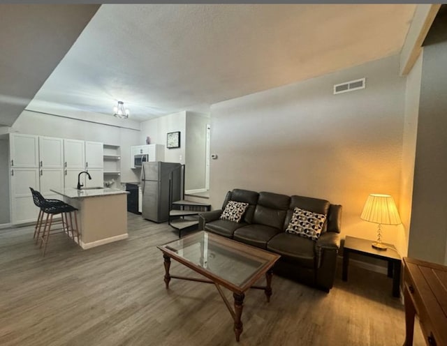 5918 Lago Vista Way Unit D32, Leander, TX 78645 - living area featuring light wood-style flooring, a chandelier, and baseboards