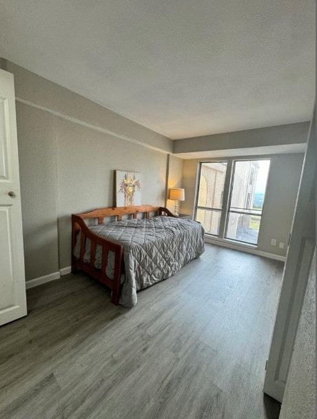 5918 Lago Vista Way Unit D32, Leander, TX 78645 - bedroom featuring wood finished floors, baseboards, and a textured ceiling