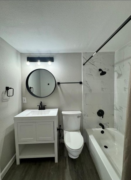 5918 Lago Vista Way Unit D32, Leander, TX 78645 - bathroom featuring wood finished floors, toilet, a textured ceiling, vanity, and shower / tub combo with curtain