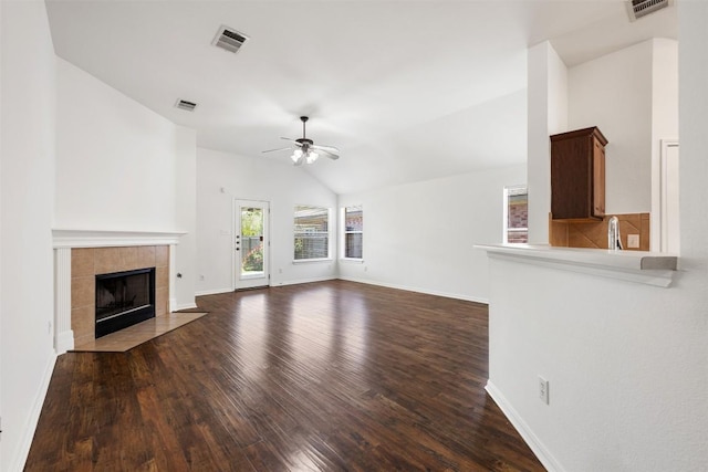 18513 Silent Water Way, Pflugerville, TX 78660 - unfurnished living room featuring ceiling fan, wood finished floors, vaulted ceiling, and a tile fireplace