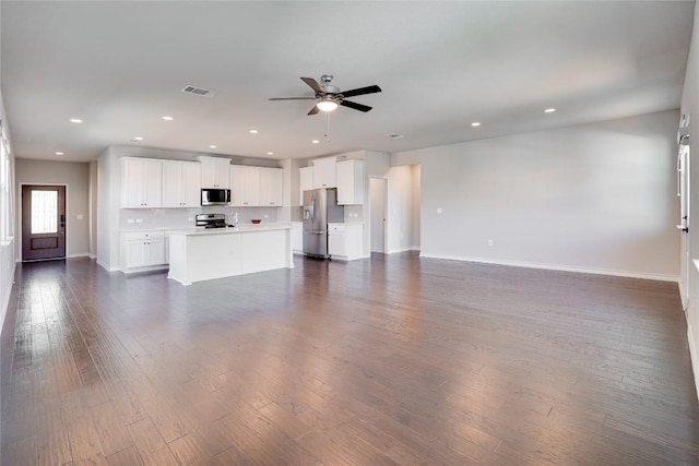 unfurnished living room featuring ceiling fan, visible vents, baseboards, dark wood-style floors, and recessed lighting