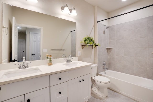 bathroom with double vanity, toilet, a sink, and tile patterned flooring