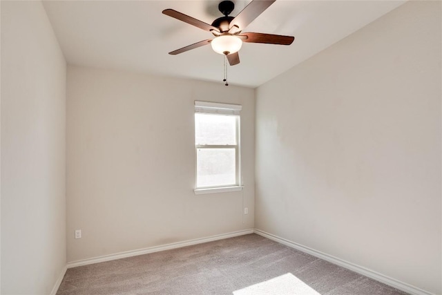 spare room featuring baseboards, a ceiling fan, and light carpet