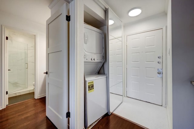washroom with stacked washer and clothes dryer, laundry area, and dark wood finished floors