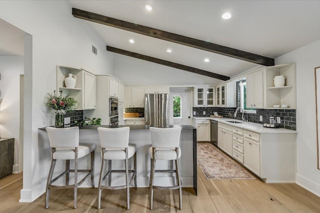 201 Westwood Ter, West Lake Hills, TX 78746 - kitchen featuring a peninsula, stainless steel appliances, open shelves, and lofted ceiling with beams