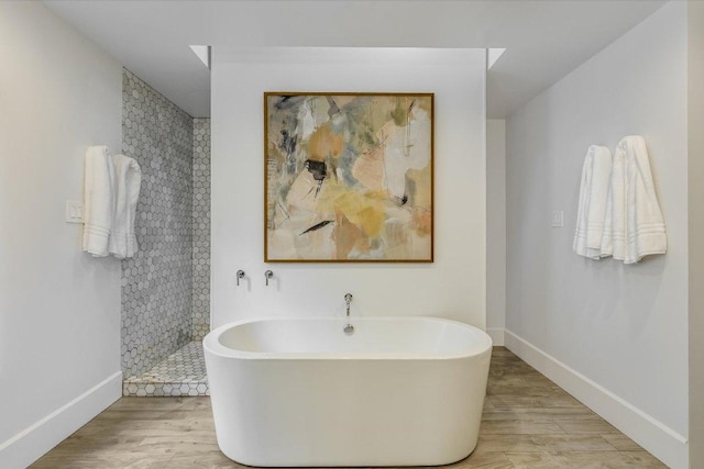 201 Westwood Ter, West Lake Hills, TX 78746 - bathroom featuring a soaking tub, baseboards, wood finished floors, and a tile shower