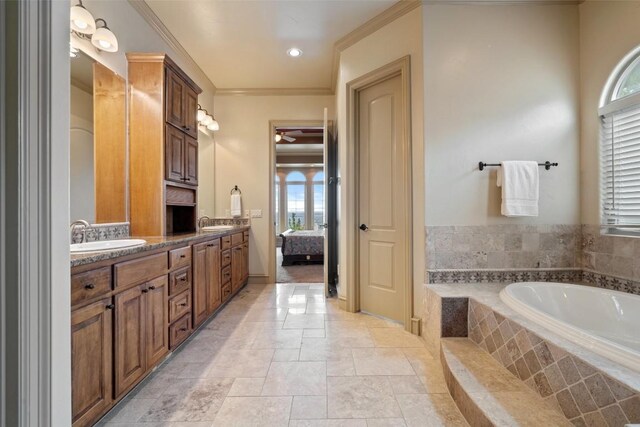 11913 Preserve Vista Ter, Austin, TX 78738 - ensuite bathroom featuring a bath, double vanity, ornamental molding, stone tile floors, and a ceiling fan