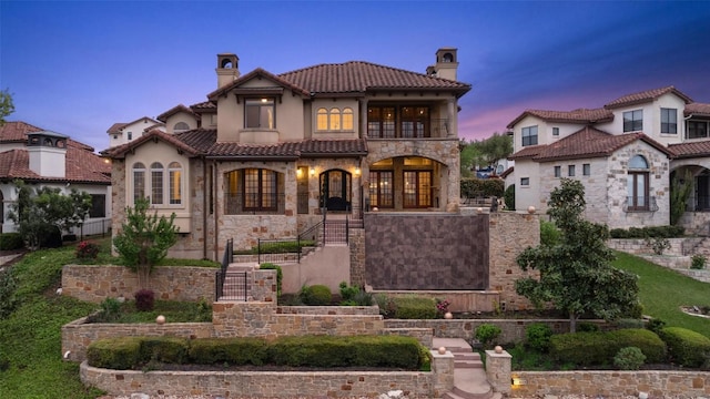 11913 Preserve Vista Ter, Austin, TX 78738 - mediterranean / spanish-style house featuring a chimney, stone siding, a balcony, stucco siding, and a tile roof