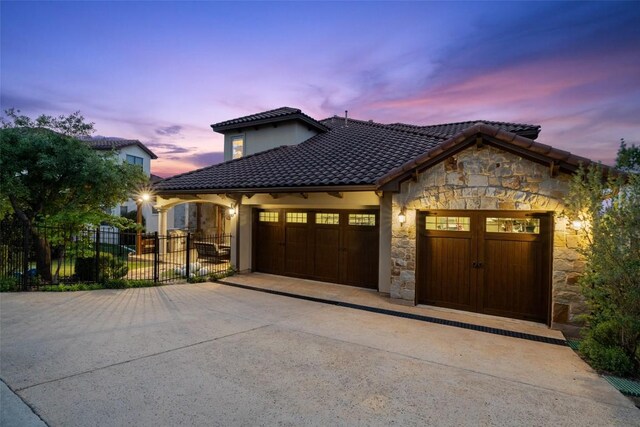 11913 Preserve Vista Ter, Austin, TX 78738 - mediterranean / spanish-style home with stone siding, concrete driveway, an attached garage, and a tiled roof