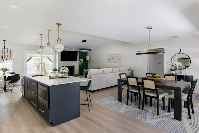 2608 Coatbridge Dr, Austin, TX 78745 - kitchen with appliances with stainless steel finishes, light wood-type flooring, light countertops, pendant lighting, and a center island with sink