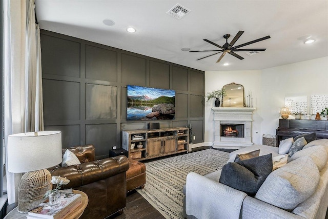 340 Fort Cobb Way, Georgetown, TX 78628 - living area featuring a decorative wall, dark wood-style flooring, a ceiling fan, a lit fireplace, and recessed lighting