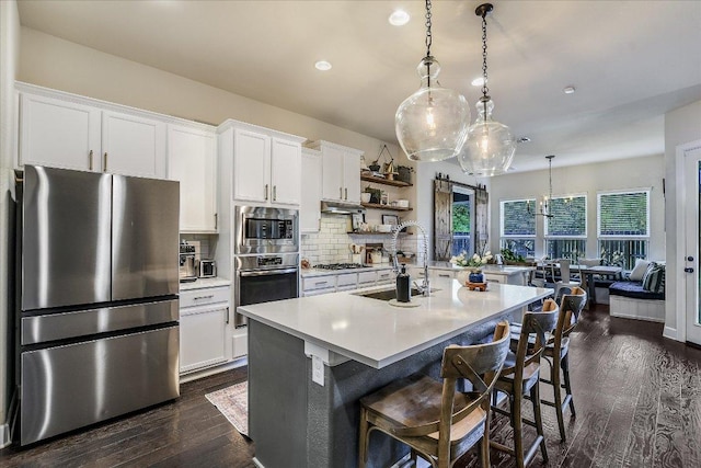 340 Fort Cobb Way, Georgetown, TX 78628 - kitchen with stainless steel appliances, light countertops, tasteful backsplash, dark wood-style floors, and white cabinetry