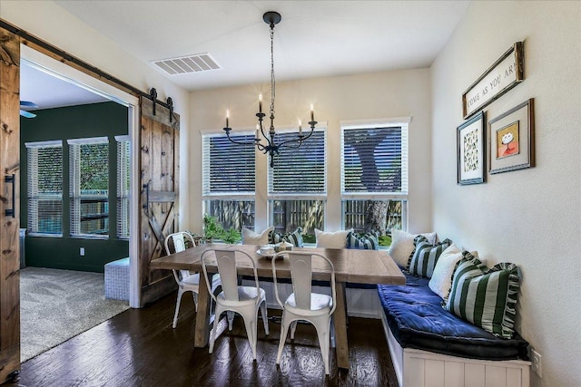 340 Fort Cobb Way, Georgetown, TX 78628 - dining space featuring a barn door, wood finished floors, and a chandelier
