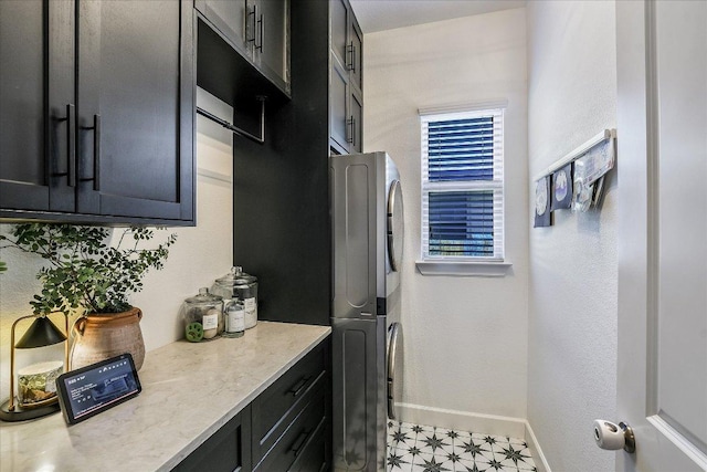 340 Fort Cobb Way, Georgetown, TX 78628 - kitchen featuring stacked washer and clothes dryer, dark cabinets, and light floors