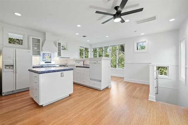 1114 Reagan Ter, Austin, TX 78704 - kitchen with white appliances, a kitchen island, white cabinetry, light wood-style floors, and a ceiling fan