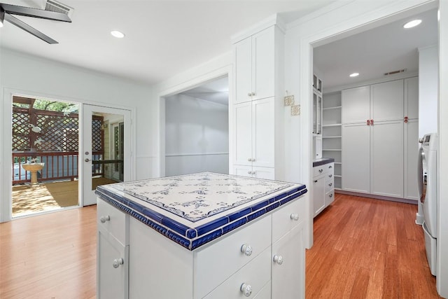 1114 Reagan Ter, Austin, TX 78704 - kitchen featuring light wood-style flooring, white cabinetry, a ceiling fan, recessed lighting, and tile counters