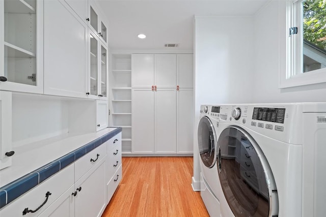 1114 Reagan Ter, Austin, TX 78704 - laundry area with washing machine and dryer, cabinet space, light wood-style flooring, and recessed lighting