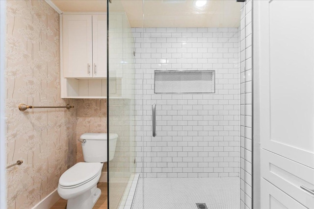 full bathroom with toilet, a stall shower, and wallpapered walls