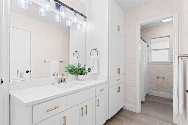 full bathroom featuring wood finished floors, vanity, and baseboards