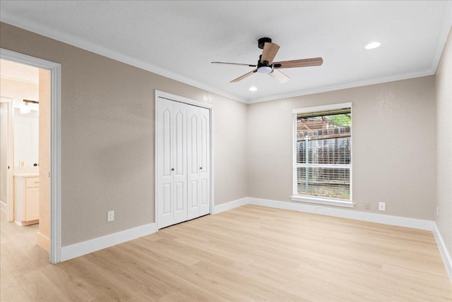 unfurnished bedroom featuring crown molding, a closet, baseboards, and light wood-type flooring