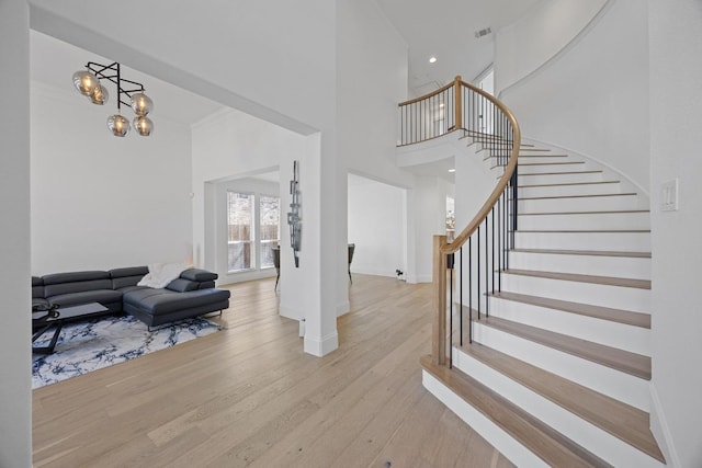 1409 Vibar Cv, Round Rock, TX 78681 - entrance foyer with a high ceiling, wood finished floors, stairs, and a chandelier