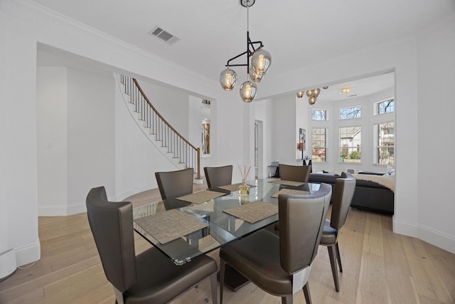 1409 Vibar Cv, Round Rock, TX 78681 - dining room with ornamental molding, a chandelier, light wood finished floors, and stairway