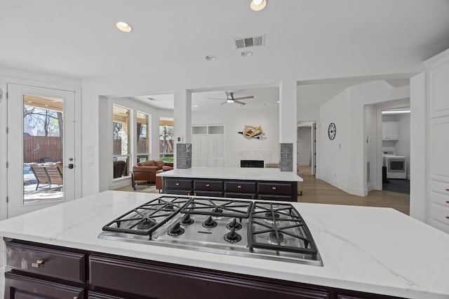1409 Vibar Cv, Round Rock, TX 78681 - kitchen with stainless steel gas stovetop, a kitchen island, open floor plan, healthy amount of natural light, and recessed lighting