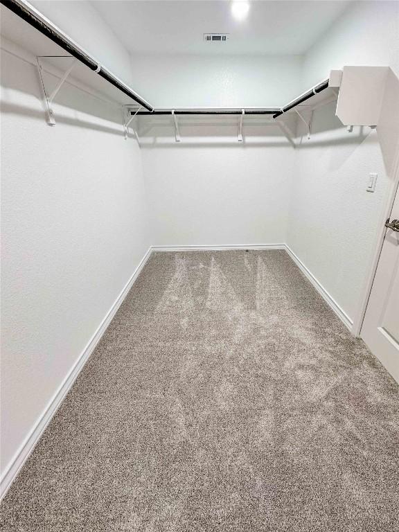 walk in closet with visible vents and carpet