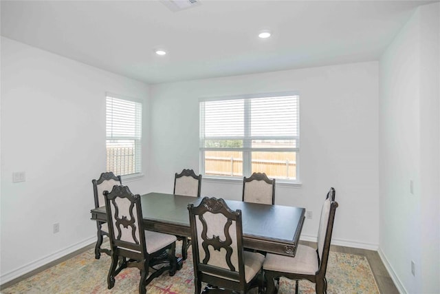 dining room with visible vents, a wealth of natural light, wood finished floors, and baseboards