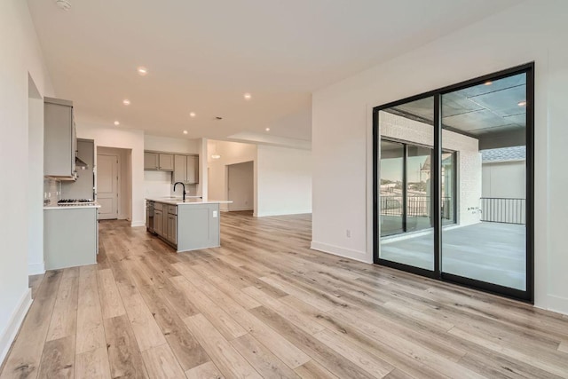 300 Alava Way, Georgetown, TX 78628 - unfurnished living room with light wood-style floors, a sink, recessed lighting, and baseboards