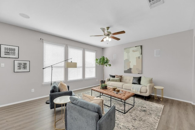 living room featuring visible vents, ceiling fan, wood finished floors, and baseboards