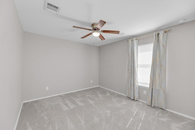 carpeted empty room with visible vents, ceiling fan, and baseboards