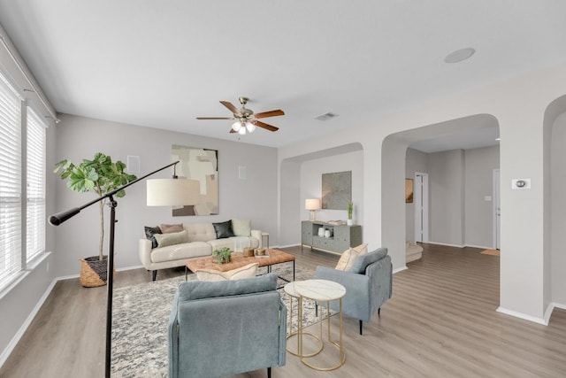 1114 Sussex Pl, Round Rock, TX 78665 - living room featuring arched walkways, light wood finished floors, and a ceiling fan