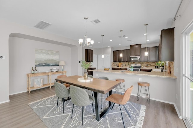 1114 Sussex Pl, Round Rock, TX 78665 - dining room with light wood-style floors, a chandelier, and recessed lighting