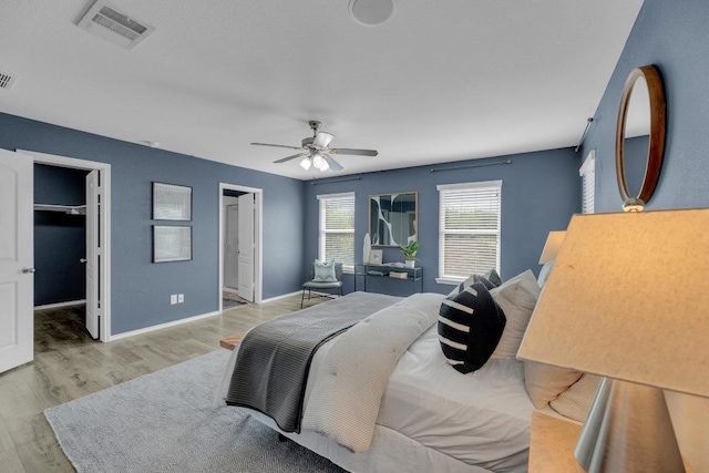 1114 Sussex Pl, Round Rock, TX 78665 - bedroom with wood finished floors, a spacious closet, ceiling fan, and ensuite bath