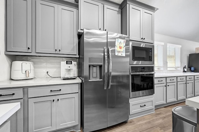 2831 Tanager Trce, Katy, TX 77493 - kitchen featuring stainless steel appliances, gray cabinetry, light countertops, and light wood-style floors