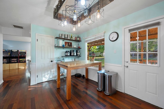 interior space with a chandelier, baseboards, visible vents, and dark wood finished floors