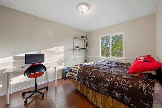 bedroom with baseboards and wood finished floors